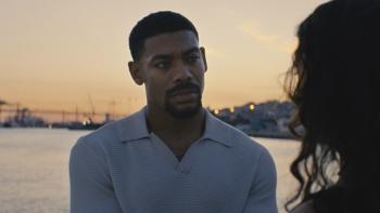 Love of Your Life movie: Aaron Pierre is intent as Margaret Qualley tells him something, the bay behind him