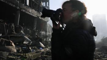 Love+War: Photojournalist Lynsey Addario takes a photo next to a destroyed building