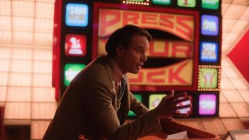 The Luckiest Man in America Movie: Host Peter Tomarken (Walton Goggins) leans forward, as if explaining something