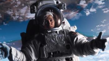 Lucy in the Sky Movie: Lucy is silhouetted against a cloudy blue sky while wearing her astronaut suit
