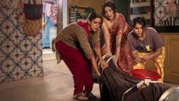 Maa Behen:  Three people in a room, moving a large object wrapped in cloth.