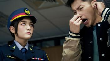 Marry My Dead Body movie: A Taiwanese police woman in hat and uniform left looks at Taiwanese man in letter jacket right pinching his nose with one hand and grabbing his ear with the other
