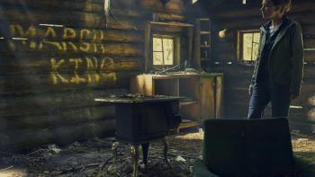 The Marsh King's Daughter Movie: Daisy Ridley stands inside a cabin in which "Marsh King" is written in letters on the wall