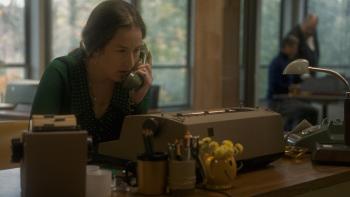 The Mastermind Movie: Looking concerned, Terri (Alana Haim) speaks on the phone, sitting at a work desk with a typewriter