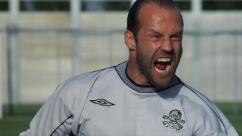 Mean Machine: A man in a grey Umbro soccer shirt with a skull-and-crossbones badge shouts aggressively on a soccer pitch