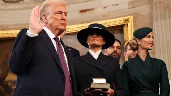 Melania movie: President Trump holds up his hand at his swearing-in ceremony; Melania holds his hand and obscures her eyes with a hat