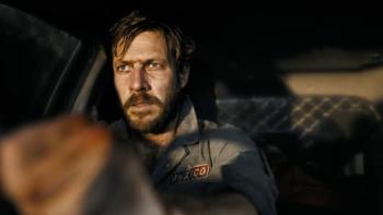 Mercy Road: A dishevelled, bearded White man sits in a car driving.