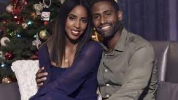 Merry Liddle Christmas: Black couple smile by Christmas tree