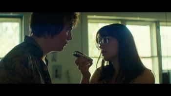 Mile End Kicks movie: Barbie Ferreira in glasses interviews Stanley Simons, holding a voice recorder to his mouth