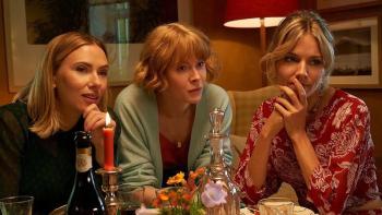 My Mother's Wedding: Scarlett Johansson, Emily Beecham, and Sienna Miller sit together leaning their elbows on a kitchen table