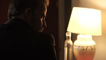 Mob Land Movie: Looking sinister, Clayton Minor (Stephen Dorff) has his back to us, face turned slightly to the right and partly illuminated by a table lamp