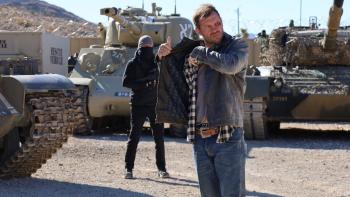 Mojave Diamonds: Jason in front of tanks. 