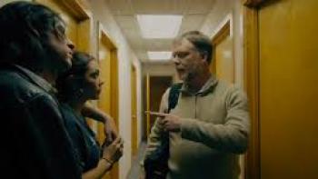 Moon Students: Mexican American man and woman on left stand in hallway facing white man center