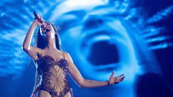 Mother Mary: Anne Hathaway sings into a microphone onstage, her image projected behind her in close-up