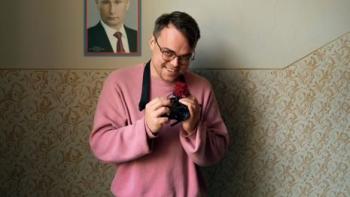 Mr. Nobody Against Putin: Teacher Pasha Talankin smiles at the camera while holding his own camera