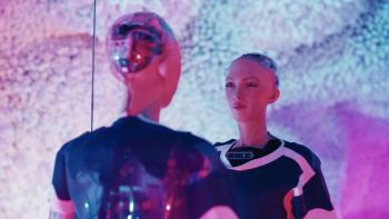 My Robot Sophia movie: In a pink light, robot Sophia smiles at her own image in a mirror
