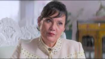 Nelma Kodama: Woman in white suit looks at camera