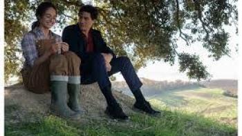 No Place to Be Single: Two people sitting under a tree on a grassy hillside, sharing a moment.