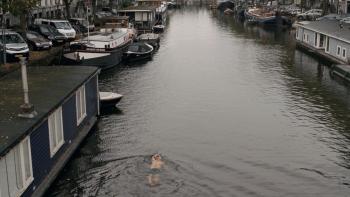 Occupied City Movie: A man swims in an Amsterdam canal