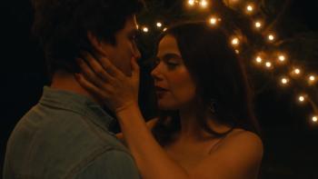 Oh, Hi! movie: Molly Gordon and Logan Lerman are about to kiss, a string of lights behind them