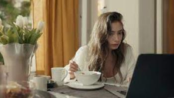 Oh Belinda: A woman eats breakfast while looking at her computer