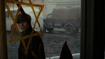 The Optimist Movie: Young Herbert, seen through a shop window, gravely regards a Jewish star painted on the glass