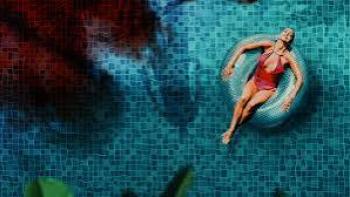 The Paradise Murders: A woman in a red swimsuit floats on a ring in a blue-tiled pool.