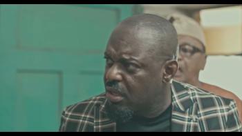 Passport: Nigerian man center leans into a conversation happening on left off screen