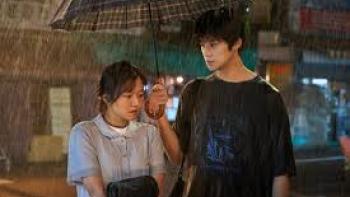 Pavane Movie: Asian young man and woman under an umbrella