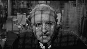 The Pawnbroker: Rod Steiger looks weary in a close-up of his head and shoulders, the inside of a pawnbrokers behind him