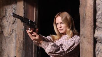 Place of Bones Movie: At the door of her ranch house, Pandora (Heather Graham) takes careful aim with her pistol
