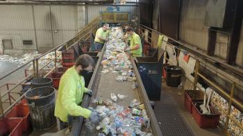Plastic Earth Movie: Workers at a recycling plant sort empty plastic bottles on a conveyor belt