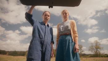 Portraits of Dangerous Women: Two women looking down, standing outdoors under a partly cloudy sky