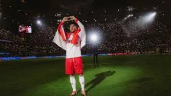Poldi: Poldi celebrating on a lit stadium field, holding up hands in shape of heart.