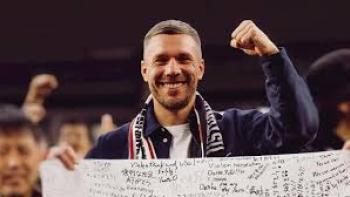 Poldi: Poldi holds signed banner, fist raised in celebration.