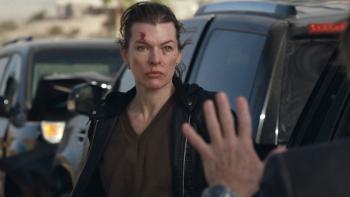 Protector Movie: Standing next to a row of black vehicles, Nikki looks threateningly at a man who holds his hands up