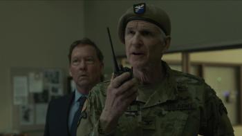 Protector Movie: Colonel Joseph Lavelle speaks into a walkie while police captain Michaels looks on from behind