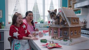 Puppy Star Christmas Movie: A dog in a gingerbread house while two girls laugh