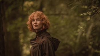 Rabbit Trap: A White woman looks cautiously over her shoulder, surrounded by lush woodland