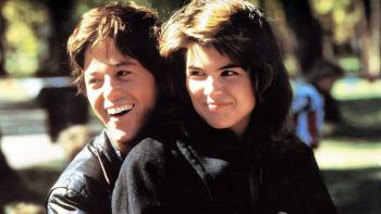 Rad movie: Bill Allen stands smiling behind Lori Laughlin as he hugs her