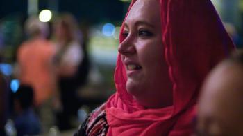Refuge Movie: Melissa Buckley, Chris' wife, wears a red hijab and smiles at something to viewers' leftt92 
