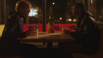 Relax, I'm from the Future: Rhys Darby and Gabrielle Graham sit at diner table at night