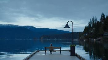 Remarkably Bright Creatures: A person sits on a dock at night.