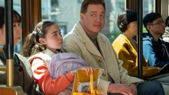 Rental Family movie: Phillip (Brendan Fraser) sits next to Mia (Shannon Gorman) on a train