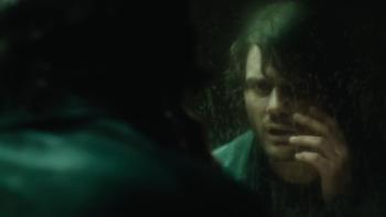 Return to Silent Hill Movie: James Sunderland (Jeremy Irvine) regards his face in a grungy mirror and touches his cheek