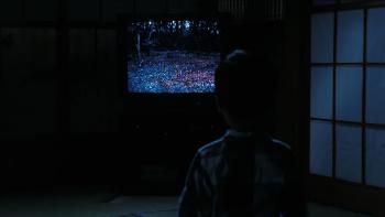 The Ring: A child is seen from behind in silhouette, sitting in front of a TV screen watching static in the dark