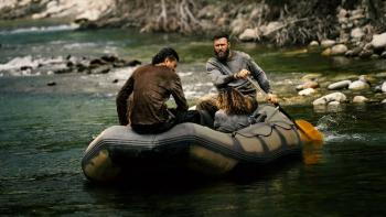 River Wild movie: Two white men paddle and a woman sits in a raft going down a river center 