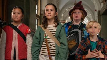 Robin and the Hoods: Four kids stand together in a line inside the town hall looking serious