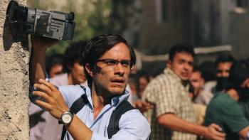 The journalist Maziar Bahari covering a street event.