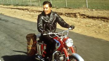 Roustabout: Elvis Presley rides a motorbike down a country road